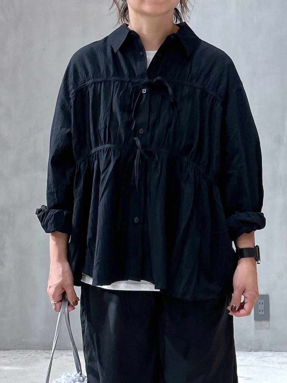 グレー系のショルダーバッグ、シルバー系のパンプス、ブラック系のその他パンツを着用したレディースの夏コーディネートの2枚目の写真