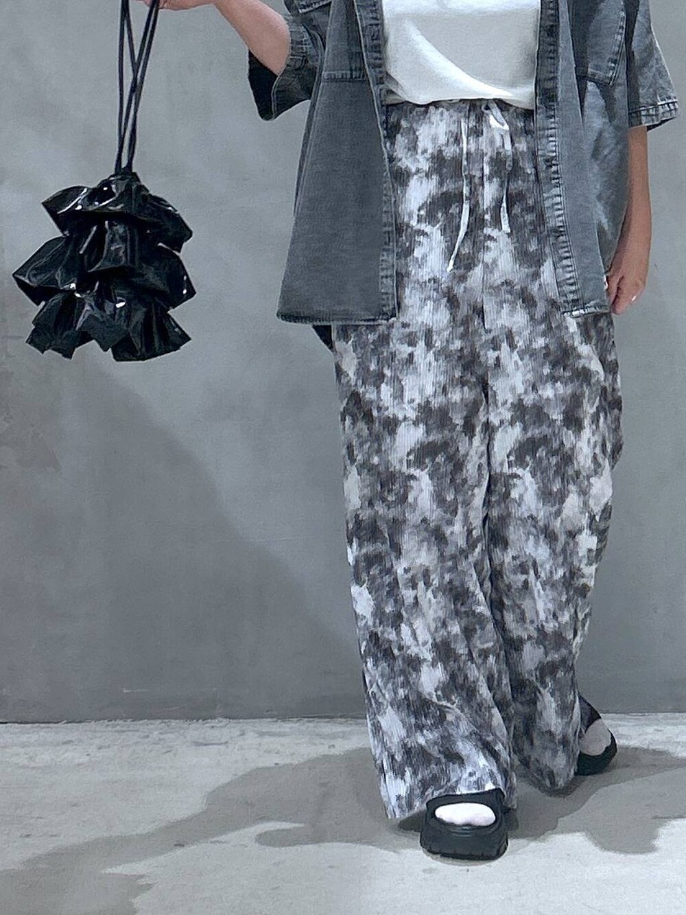 ブラック系のショルダーバッグ、ブラック系のスニーカー、ブルー系のシャツ/ブラウスを着用したレディースの夏コーディネートの4枚目の写真