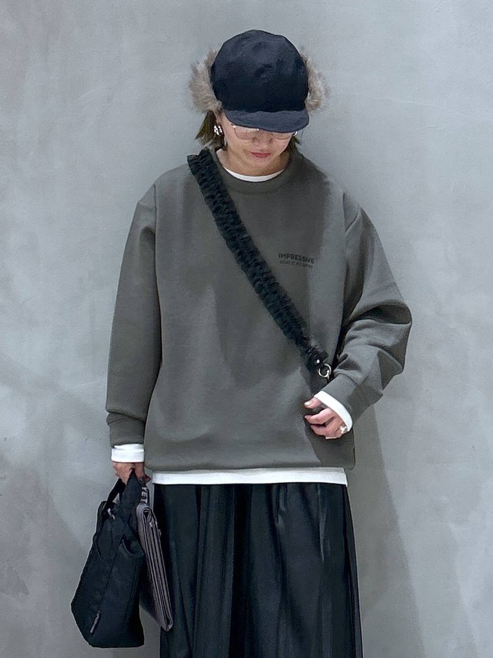 グレー系のスニーカー、ブラック系のスカート、グレー系のアウトドアグッズを着用したレディースの秋コーディネートの3枚目の写真