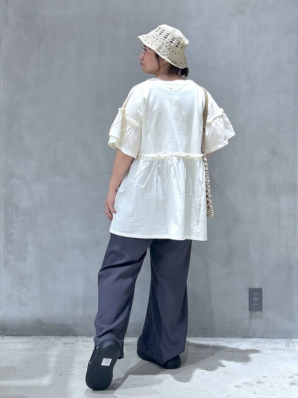 ベージュ系のトートバッグ、ブラック系のサンダル、グレー系のその他パンツを着用したレディースの夏コーディネートの2枚目の写真