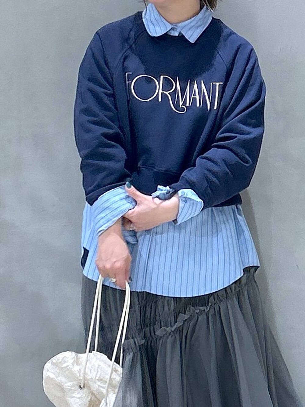 ホワイト系のショルダーバッグ、ブルー系のシャツ/ブラウス、ブルー系のスウェットを着用したレディースの春コーディネートの2枚目の写真