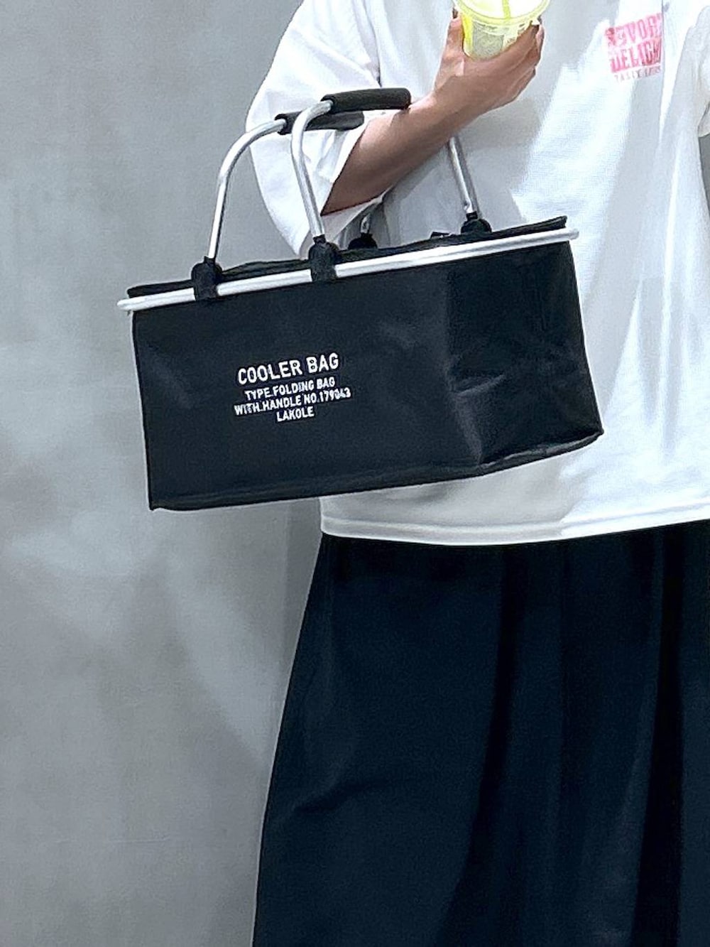 ブルー系のデニムパンツ、ブラック系のスニーカー、ブラック系のワンピースを着用したレディースの春コーディネートの3枚目の写真