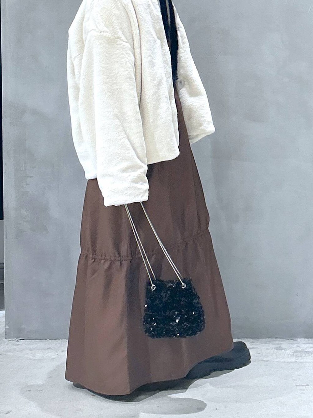 ベージュ系のブルゾン、ブラック系のブーツ、ブラウン系のワンピースを着用したレディースの秋コーディネートの5枚目の写真