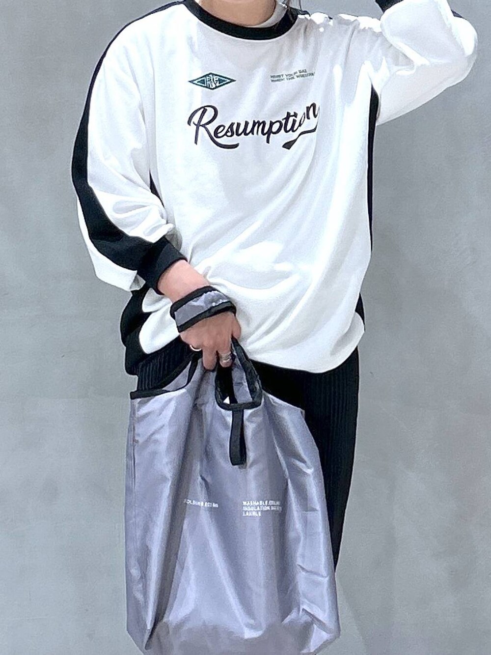 ホワイト系のスニーカー、ブラック系のスカート、グレー系のエコバッグ/サブバッグを着用したレディースの秋コーディネートの2枚目の写真