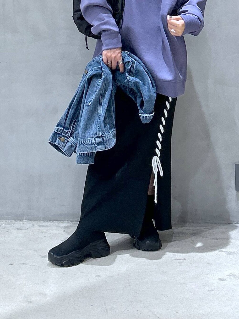 ブラック系のショルダーバッグ、パープル系のスウェット、ブラック系のブーツを着用したレディースの秋コーディネートの4枚目の写真