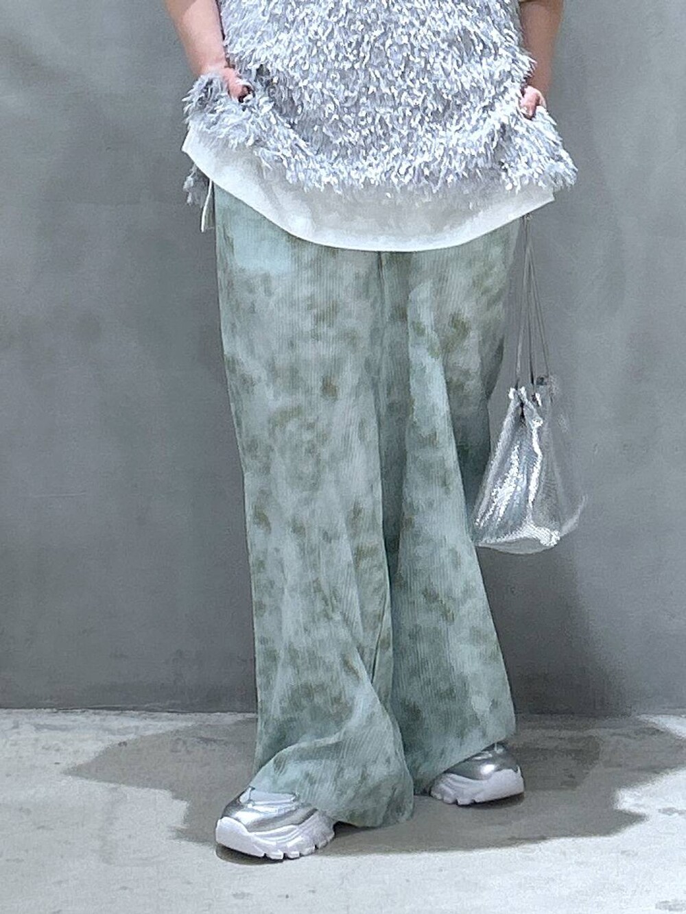 その他のショルダーバッグ、シルバー系のスニーカー、グレー系のベストを着用したレディースの春コーディネートの4枚目の写真