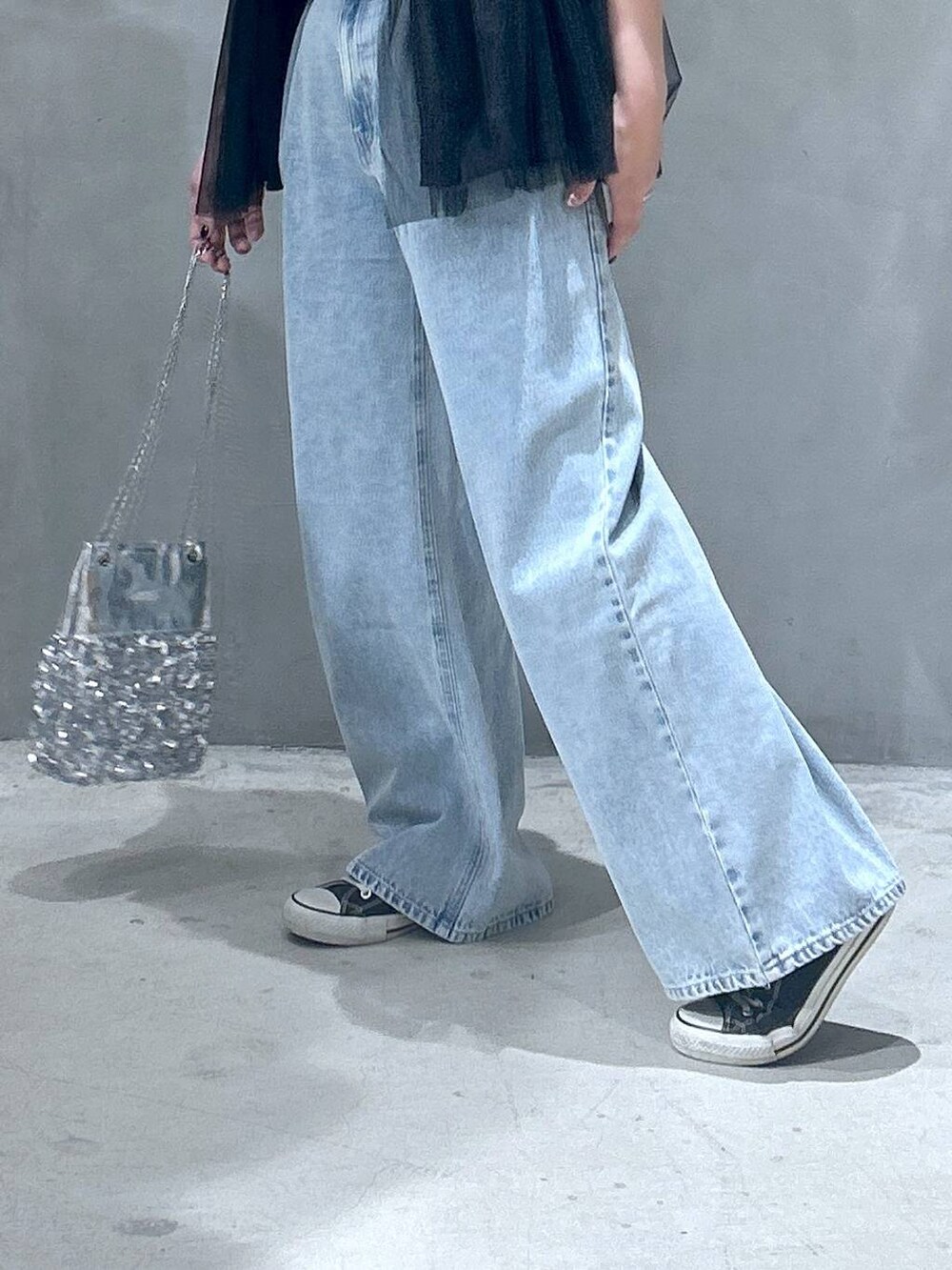 ブルー系のデニムパンツ、その他のショルダーバッグ、ブラック系のベストを着用したレディースの春コーディネートの3枚目の写真