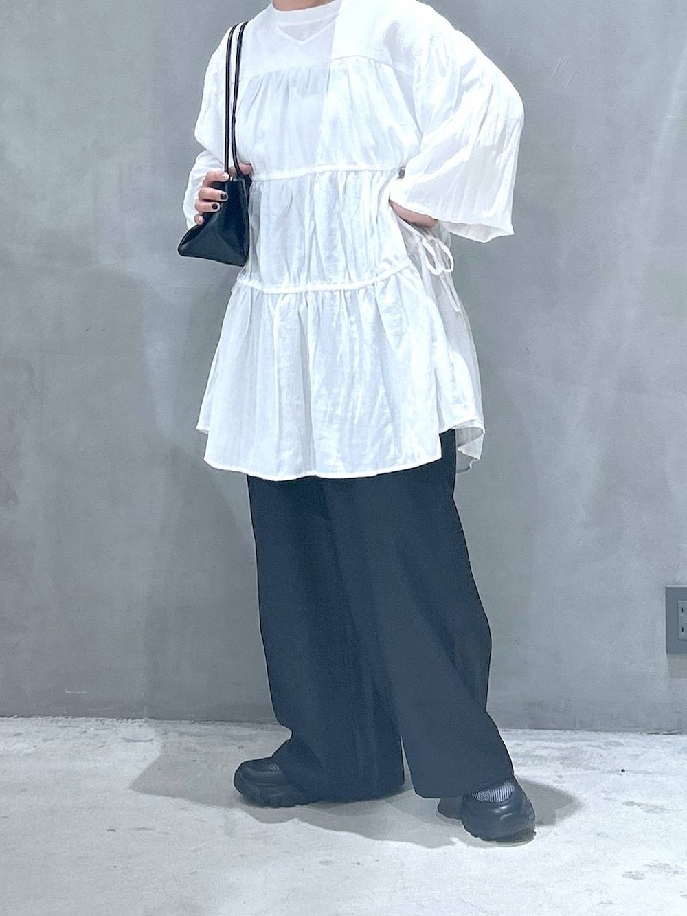 ブラック系のトートバッグ、ブラック系のスニーカー、ブラック系のその他パンツを着用したレディースの春コーディネートの5枚目の写真