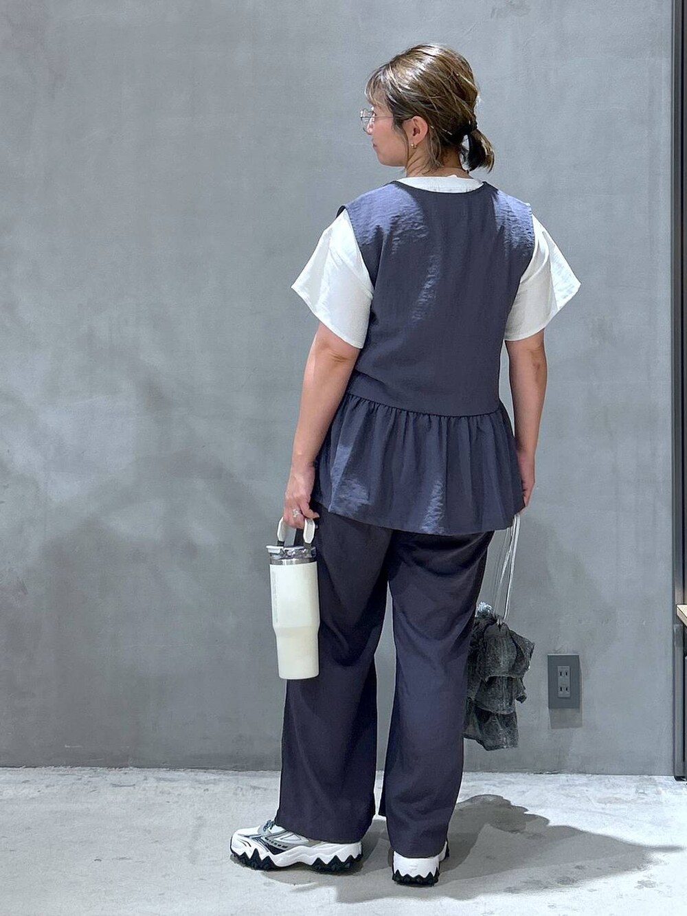 シルバー系のショルダーバッグ、ホワイト系のスニーカー、グレー系のその他パンツを着用したレディースの夏コーディネートの2枚目の写真