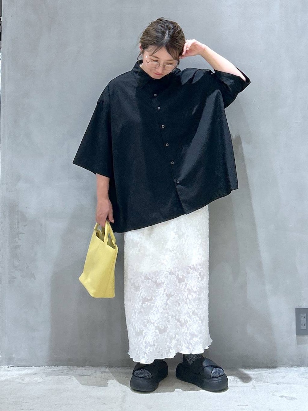 ブラック系のサンダル、ホワイト系のスカート、ブラック系のシャツ/ブラウスを着用したレディースの夏コーディネートの6枚目の写真