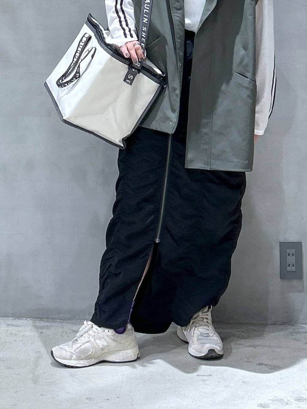 グリーン系のブルゾン、ホワイト系のTシャツ/カットソー、ブラック系のスカートを着用したレディースの秋コーディネートの4枚目の写真