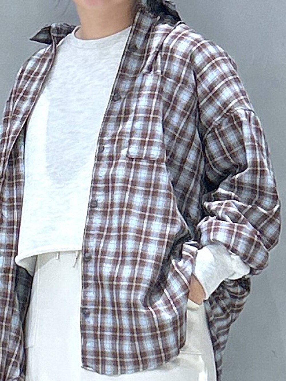 ベージュ系のスウェット、ブラウン系のシャツ/ブラウス、ホワイト系のスカートを着用したレディースの冬コーディネートの4枚目の写真