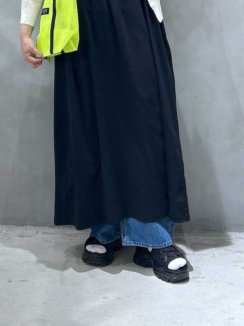 ブルー系のデニムパンツ、ブラック系のスニーカー、ホワイト系のカーディガン/ボレロを着用したレディースの春コーディネートの5枚目の写真