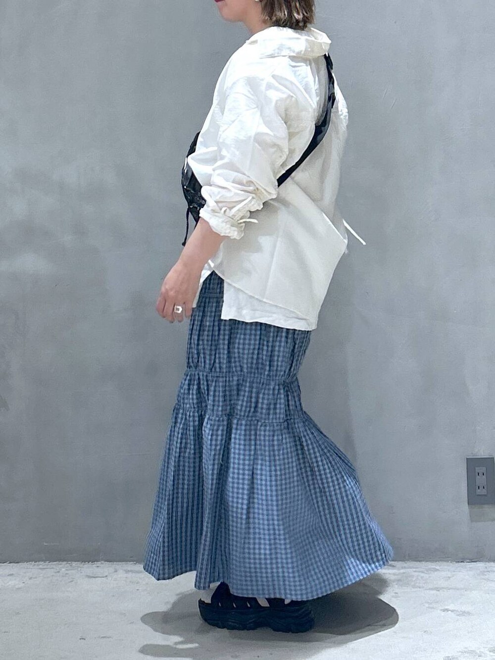 ブラック系のボディバッグ/ウエストポーチ、ブラック系のスニーカー、ホワイト系のシャツ/ブラウスを着用したレディースの春コーディネートの5枚目の写真