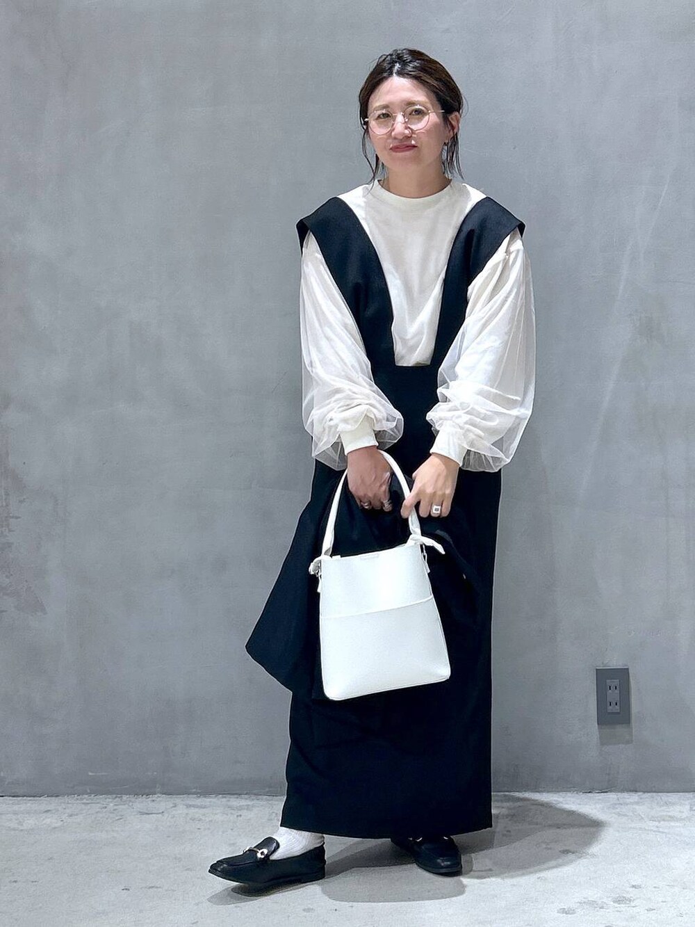 ブラック系のテーラードジャケット、ホワイト系のショルダーバッグ、ブラック系のローファーを着用したレディースの秋コーディネートの2枚目の写真