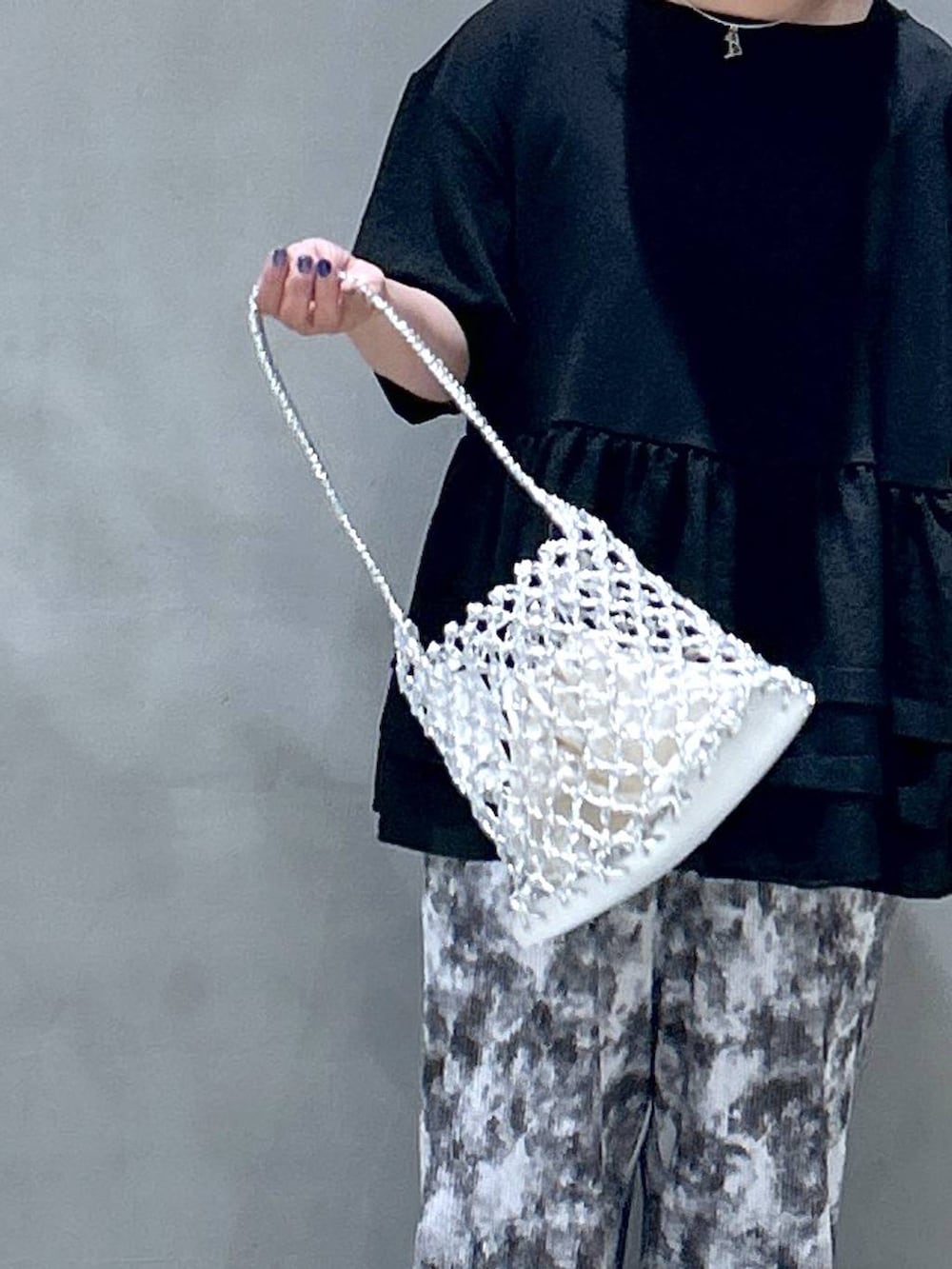 シルバー系のかごバッグ、グレー系のその他パンツ、その他のサングラスを着用したレディースの春コーディネートの5枚目の写真