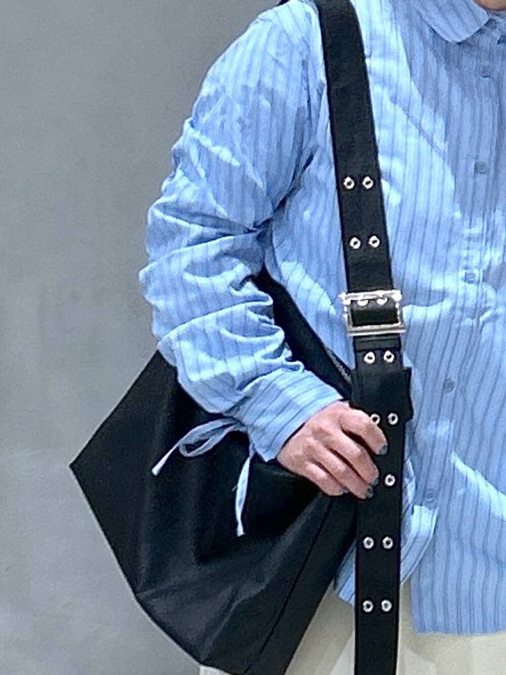 ホワイト系のスカート、ブラック系のスニーカー、ブラック系のショルダーバッグを着用したレディースの春コーディネートの5枚目の写真