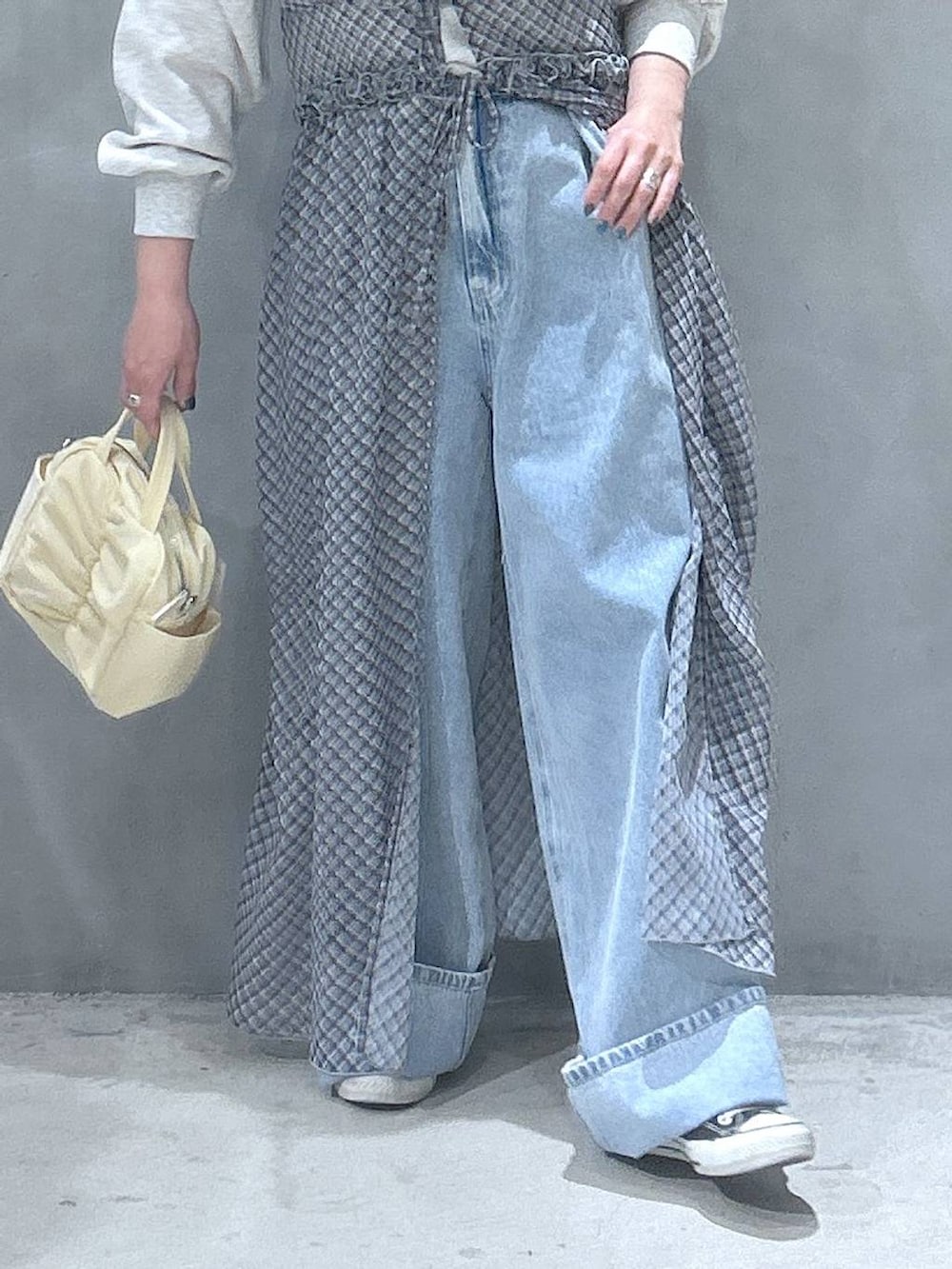 ブルー系のデニムパンツ、ベージュ系のスウェット、ブルー系のワンピースを着用したレディースの春コーディネートの5枚目の写真