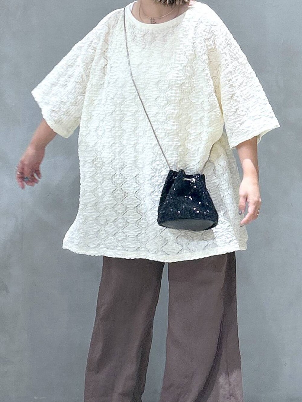 ブラック系のショルダーバッグ、ホワイト系のタンクトップ、ブラック系のサンダルを着用したレディースの夏コーディネートの3枚目の写真