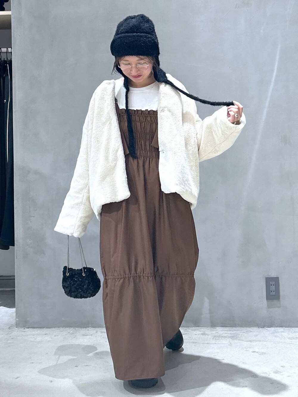 ベージュ系のブルゾン、ブラック系のブーツ、ブラウン系のワンピースを着用したレディースの秋コーディネートの7枚目の写真