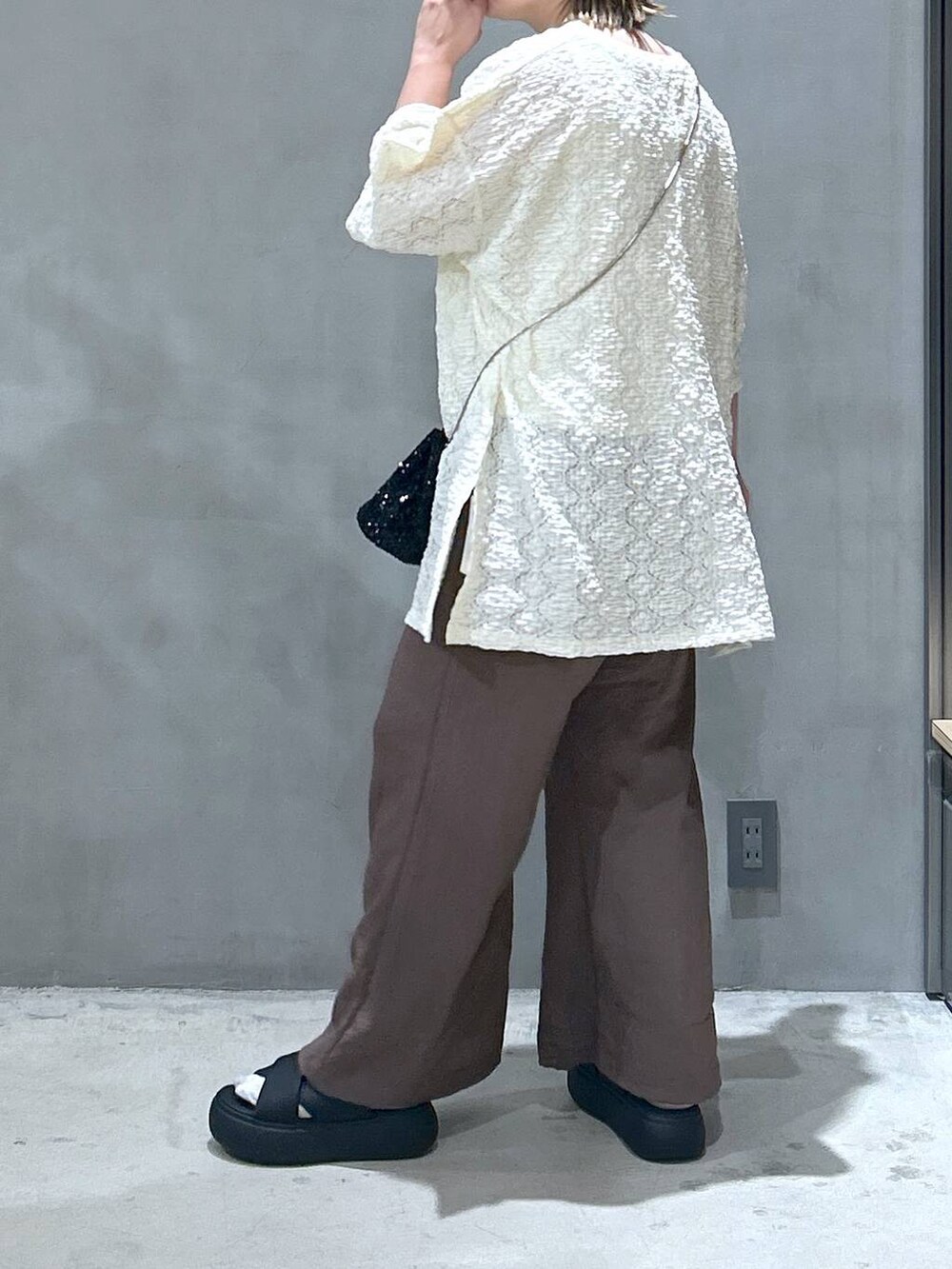 ブラック系のショルダーバッグ、ホワイト系のタンクトップ、ブラック系のサンダルを着用したレディースの夏コーディネートの2枚目の写真