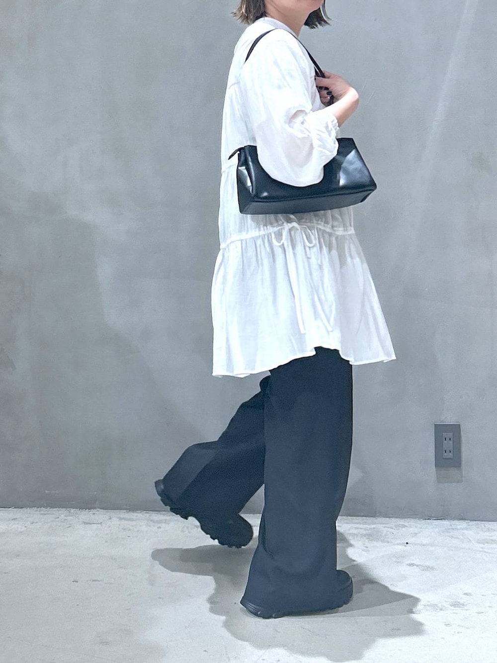 ブラック系のトートバッグ、ブラック系のスニーカー、ブラック系のその他パンツを着用したレディースの春コーディネートの3枚目の写真