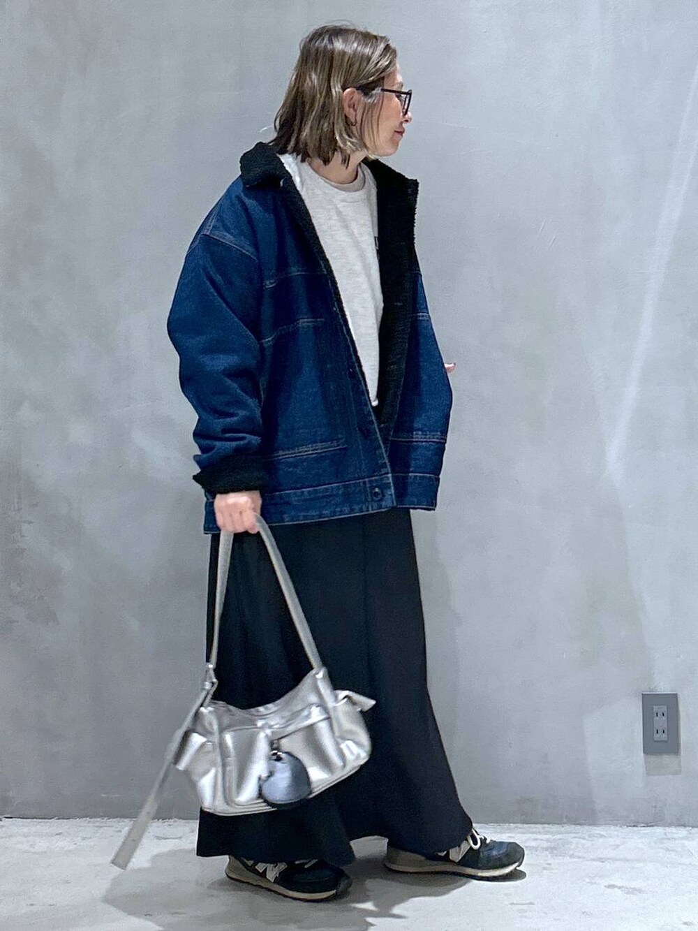 ブラック系のスカート、その他のショルダーバッグ、ブルー系のブルゾンを着用したレディースの冬コーディネートの2枚目の写真