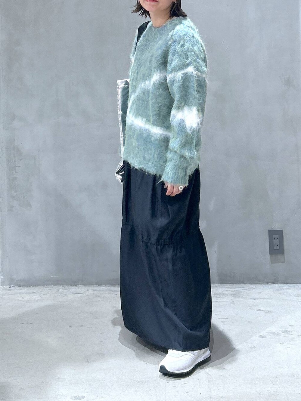 ホワイト系のスニーカー、グリーン系のニット/セーター、シルバー系のトートバッグを着用したレディースの秋コーディネートの5枚目の写真