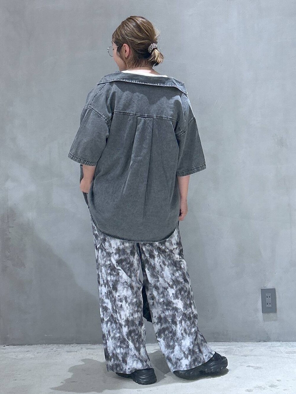 ブラック系のショルダーバッグ、ブラック系のスニーカー、ブルー系のシャツ/ブラウスを着用したレディースの夏コーディネートの2枚目の写真