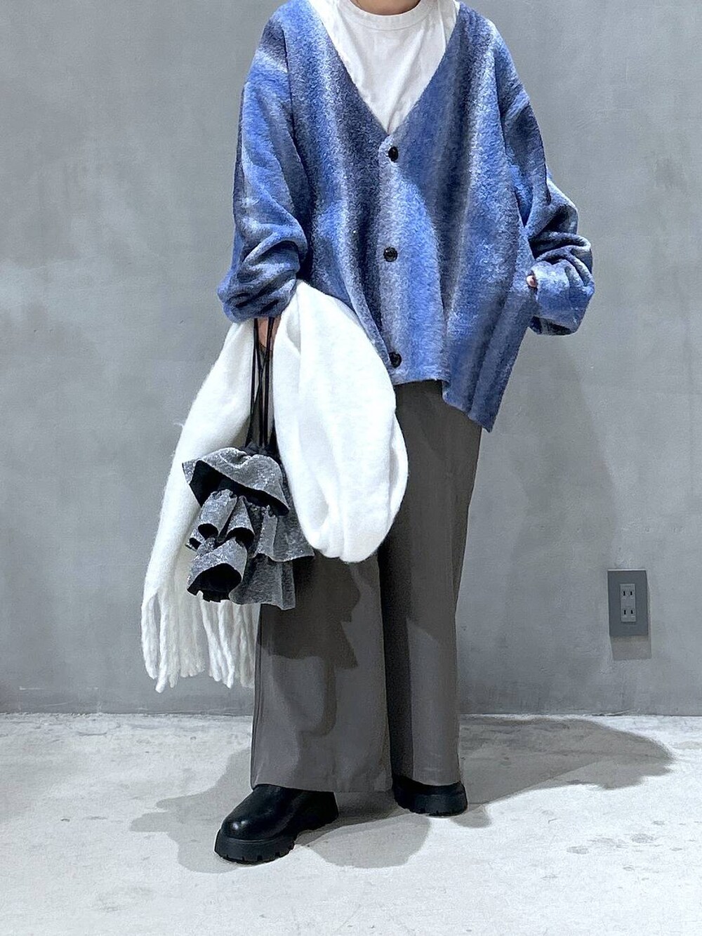 ブルー系のカーディガン/ボレロ、ベージュ系のその他パンツ、シルバー系のショルダーバッグを着用したレディースの冬コーディネートの3枚目の写真