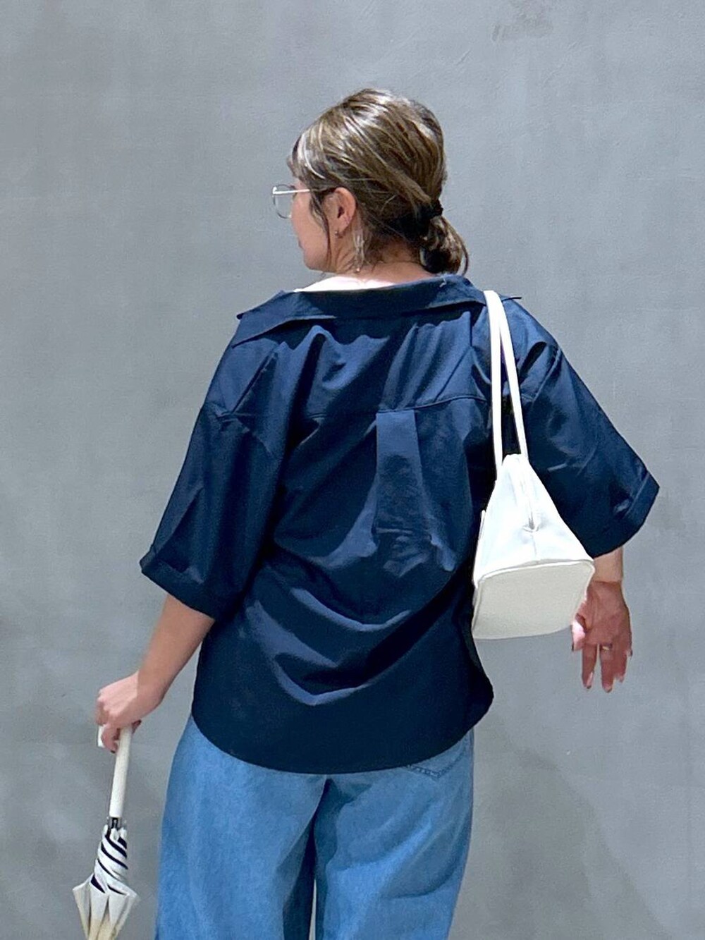 ホワイト系のスニーカー、ホワイト系のボストンバッグ、ブルー系のシャツ/ブラウスを着用したレディースの夏コーディネートの4枚目の写真