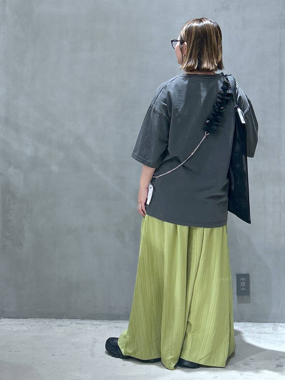 ブラック系のスニーカー、グリーン系のその他パンツ、グレー系のTシャツ/カットソーを着用したレディースの春コーディネートの2枚目の写真