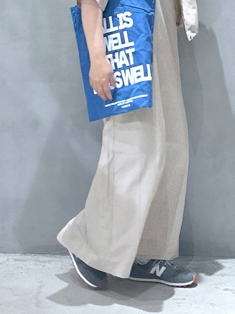 グレー系のスニーカー、ブルー系のトートバッグ、グレー系のTシャツ/カットソーを着用したレディースの春コーディネートの7枚目の写真