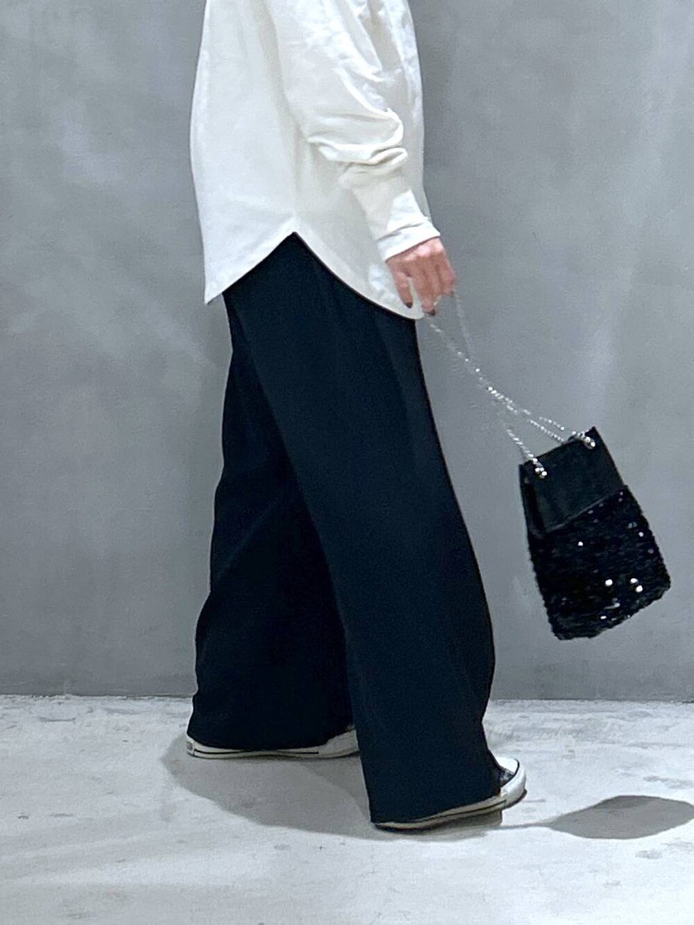 ブラック系のその他パンツ、ブラック系のショルダーバッグ、ベージュ系のTシャツ/カットソーを着用したレディースの冬コーディネートの4枚目の写真