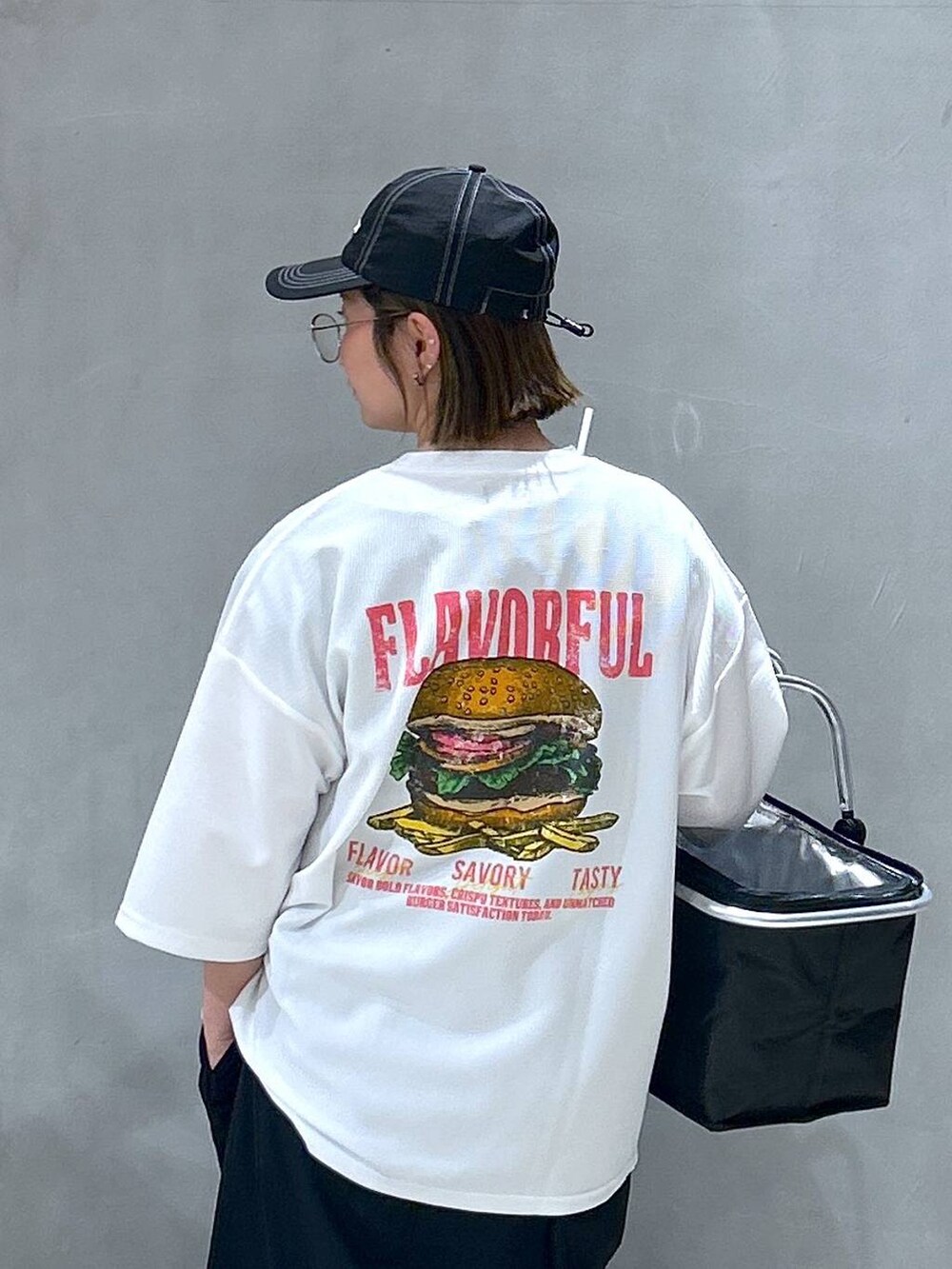 ブルー系のデニムパンツ、ブラック系のスニーカー、ブラック系のワンピースを着用したレディースの春コーディネートの4枚目の写真