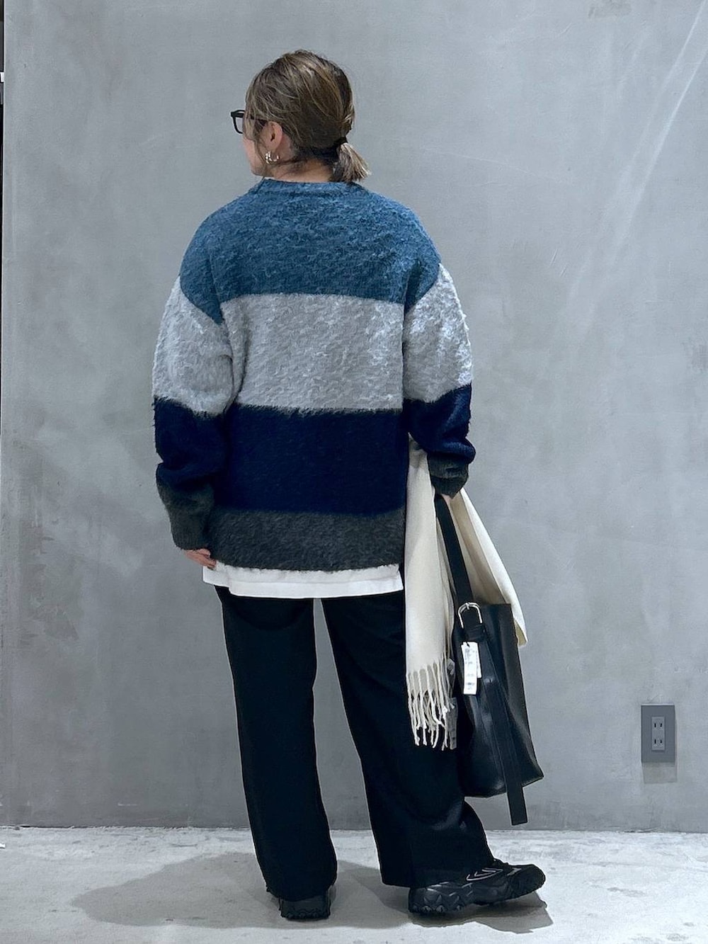 グレー系のスニーカー、ブラック系のその他パンツ、ブルー系のニット/セーターを着用したレディースの冬コーディネートの2枚目の写真
