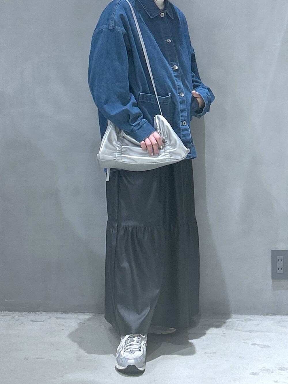 ブラック系のワンピース、シルバー系のショルダーバッグ、ブルー系のデニムジャケットを着用したレディースの冬コーディネートの5枚目の写真