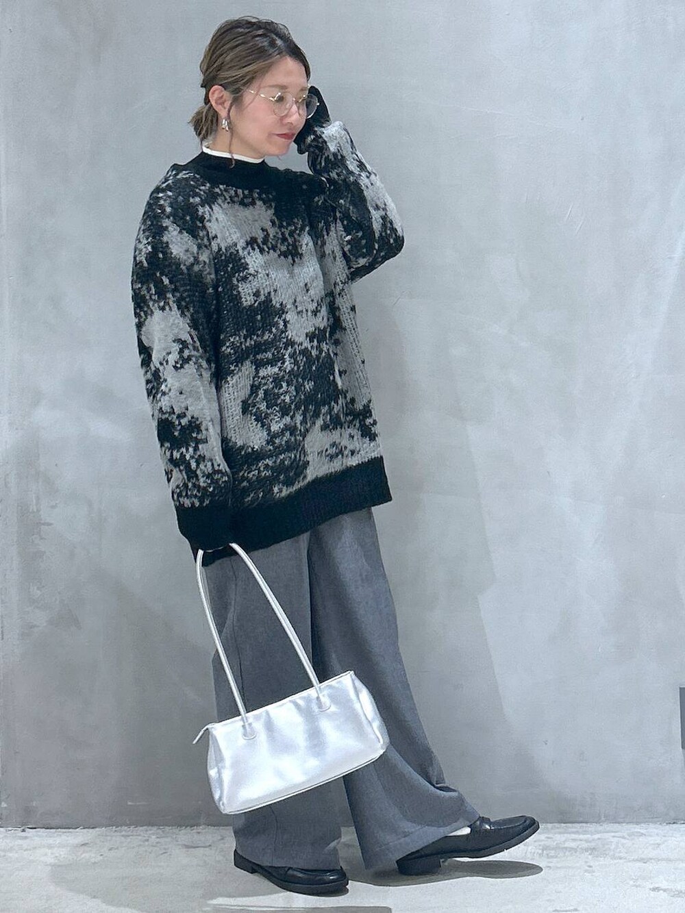 ブラック系のニット/セーター、ブラック系のローファー、シルバー系のトートバッグを着用したレディースの秋コーディネートの5枚目の写真