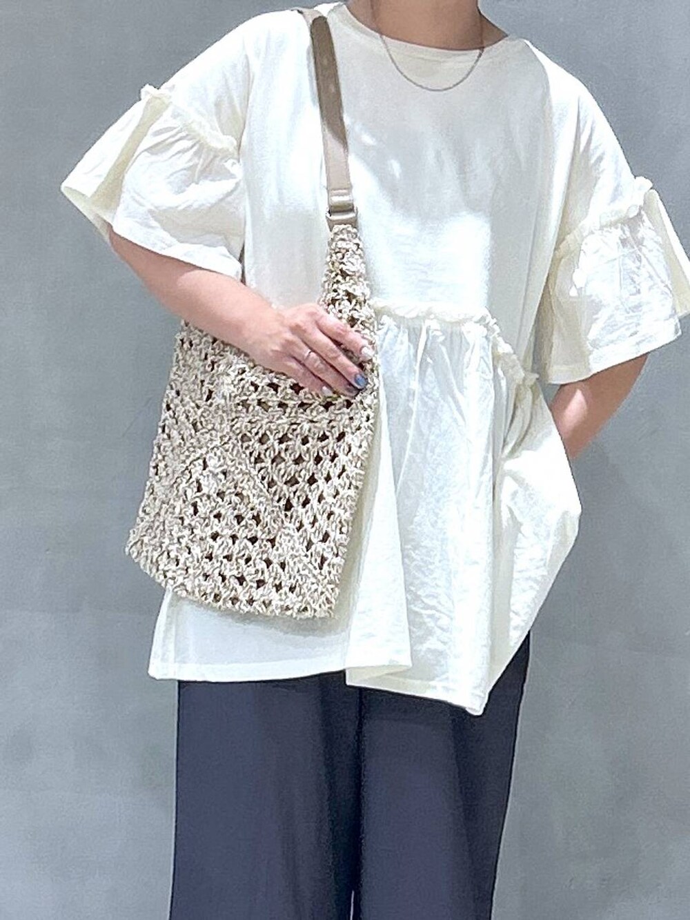 ベージュ系のトートバッグ、ブラック系のサンダル、グレー系のその他パンツを着用したレディースの夏コーディネートの3枚目の写真