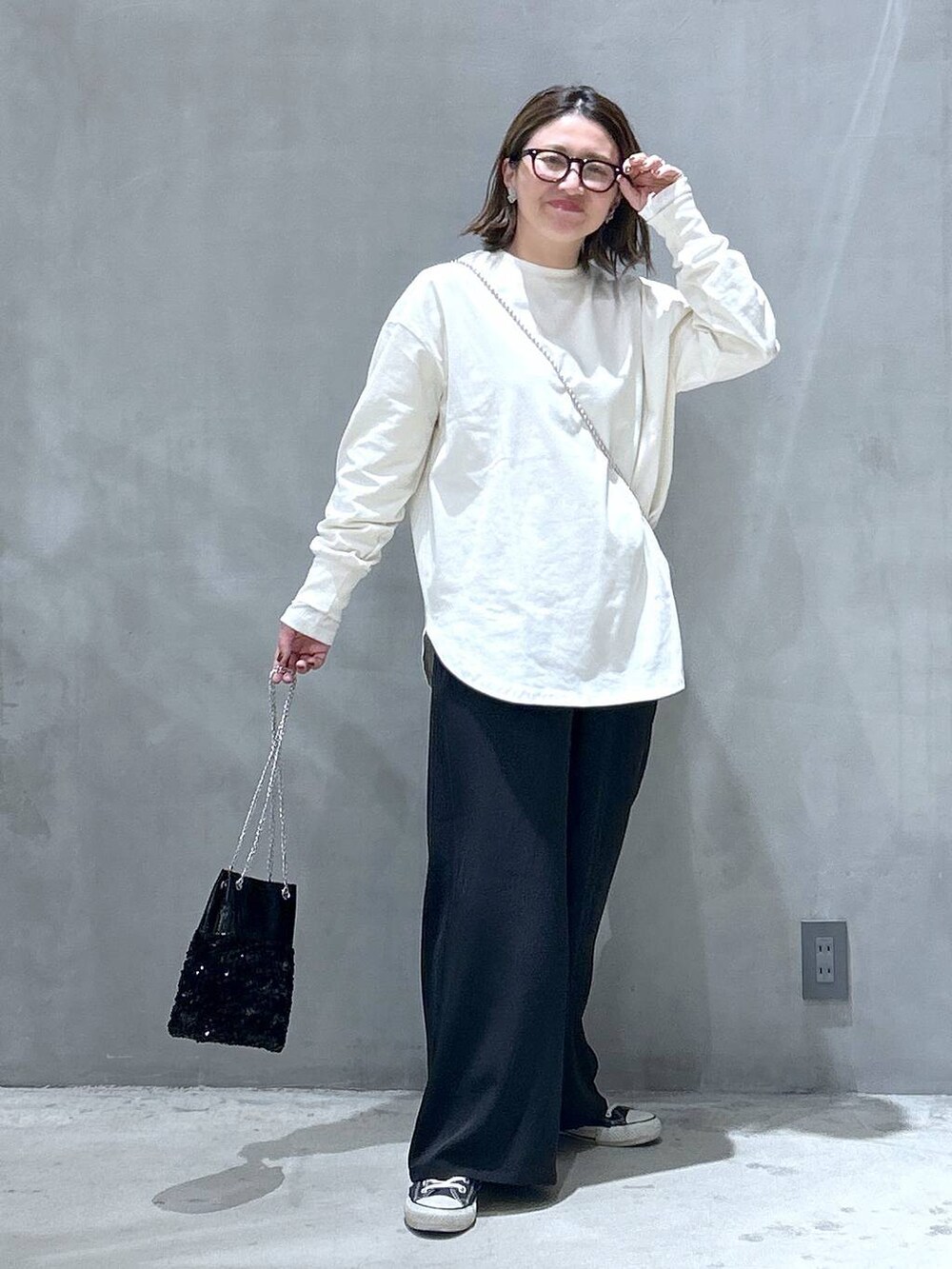 ブラック系のその他パンツ、ブラック系のショルダーバッグ、ベージュ系のTシャツ/カットソーを着用したレディースの冬コーディネートの7枚目の写真