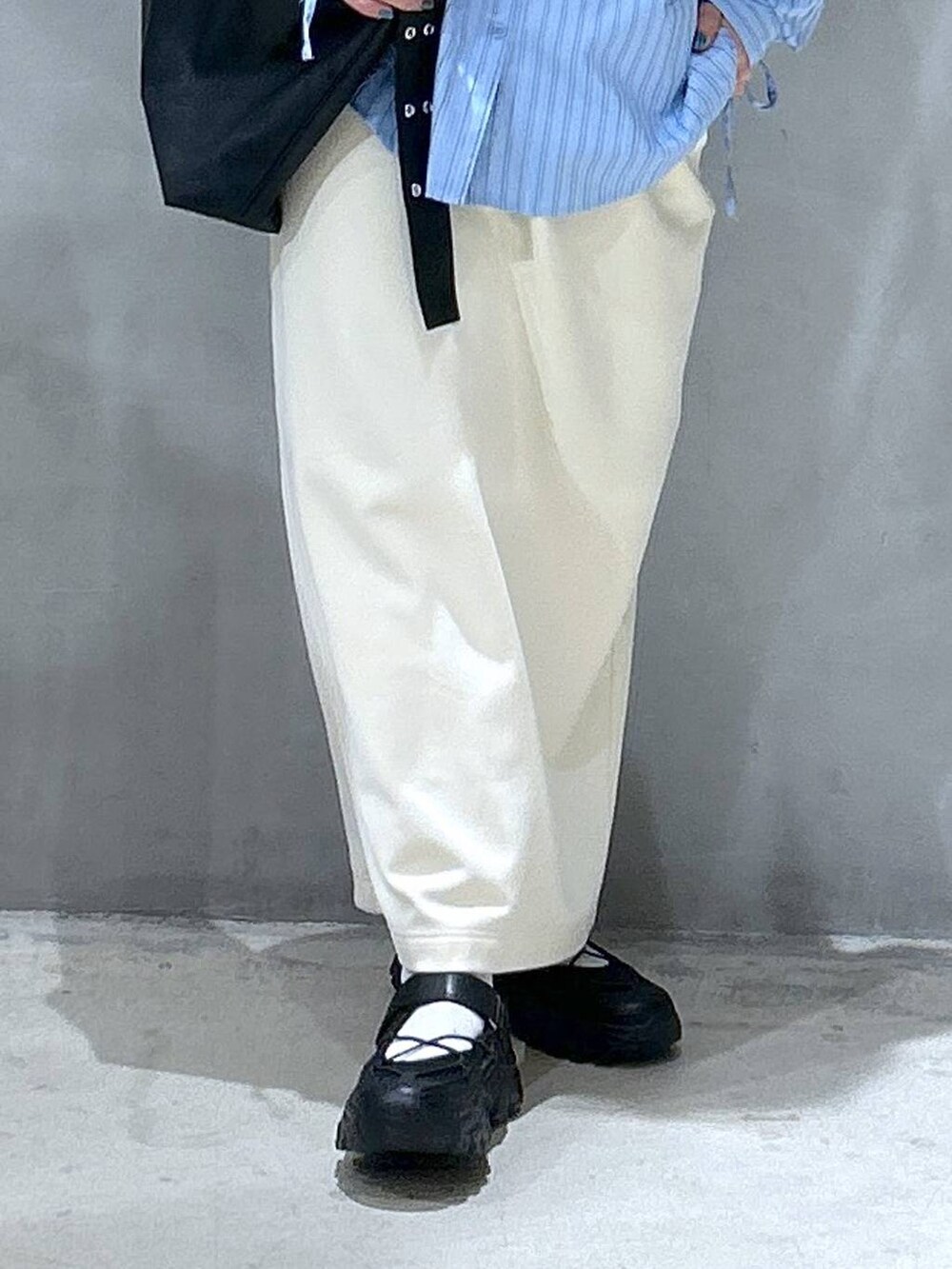 ホワイト系のスカート、ブラック系のスニーカー、ブラック系のショルダーバッグを着用したレディースの春コーディネートの4枚目の写真