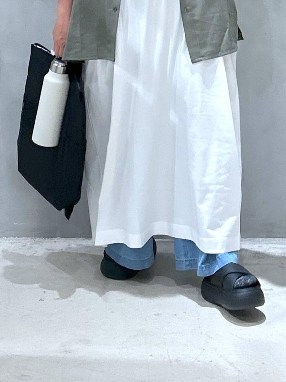 ブラック系のバックパック/リュック、グリーン系のシャツ/ブラウス、ブラック系のサンダルを着用したレディースの夏コーディネートの4枚目の写真