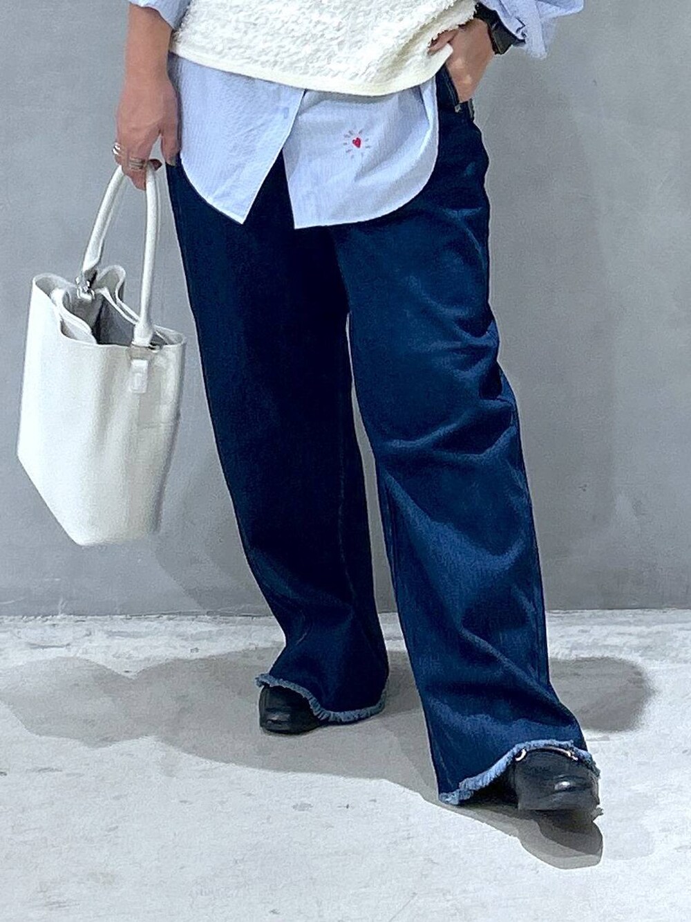 ブルー系のデニムパンツ、ブルー系のシャツ/ブラウス、ホワイト系のショルダーバッグを着用したレディースの秋コーディネートの4枚目の写真