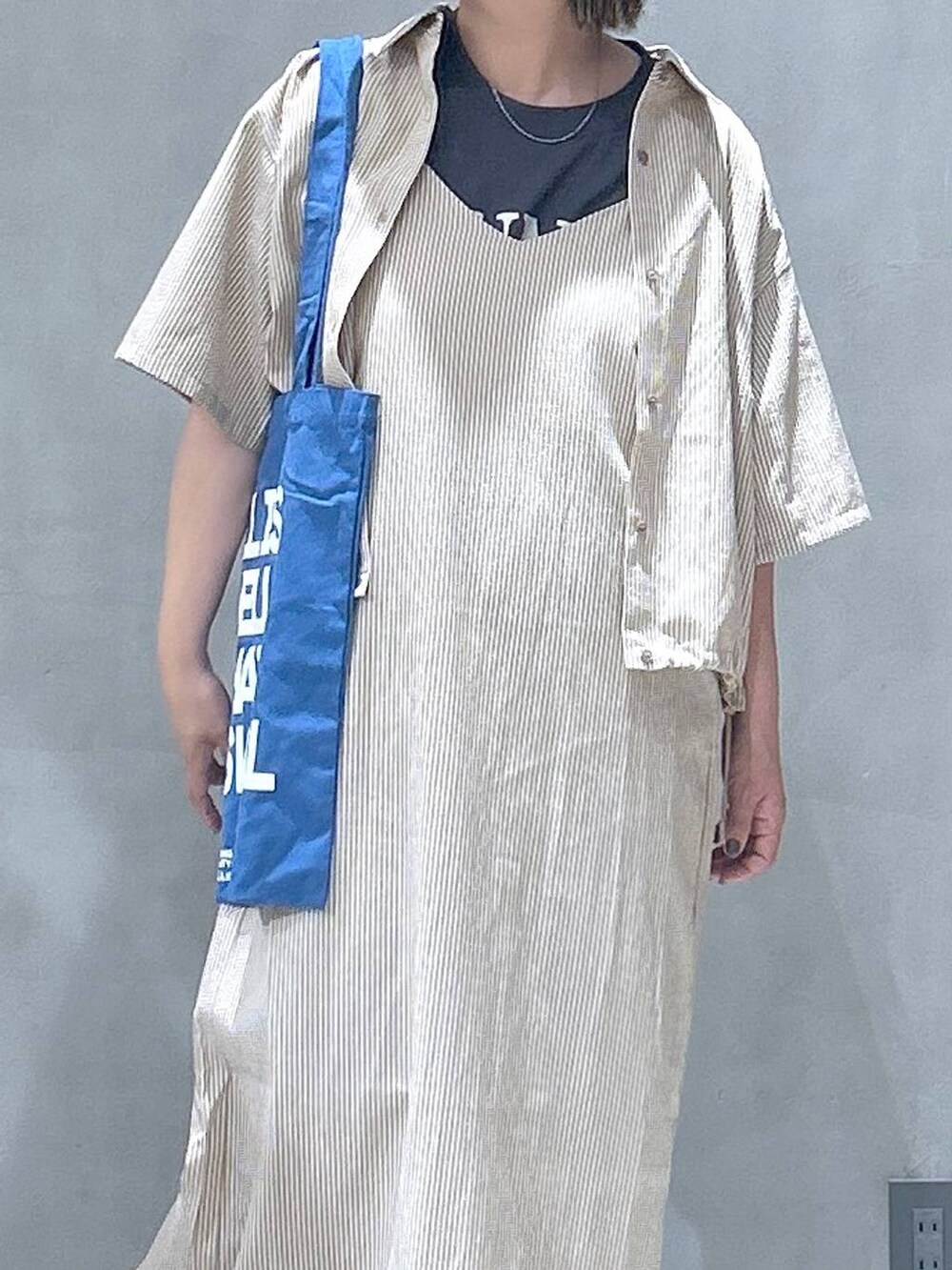 グレー系のスニーカー、ブルー系のトートバッグ、グレー系のTシャツ/カットソーを着用したレディースの春コーディネートの4枚目の写真