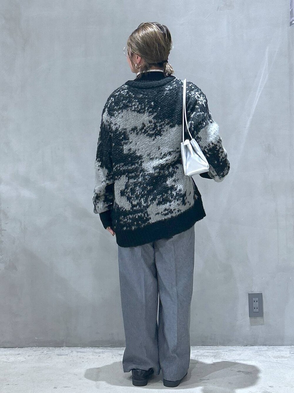 ブラック系のニット/セーター、ブラック系のローファー、シルバー系のトートバッグを着用したレディースの秋コーディネートの2枚目の写真