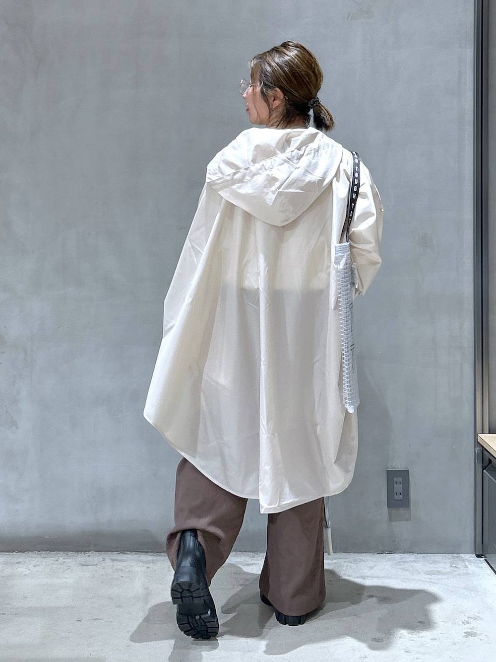 ブラック系のレインシューズ、ホワイト系のTシャツ/カットソー、ブラック系のトートバッグを着用したレディースの夏コーディネートの2枚目の写真