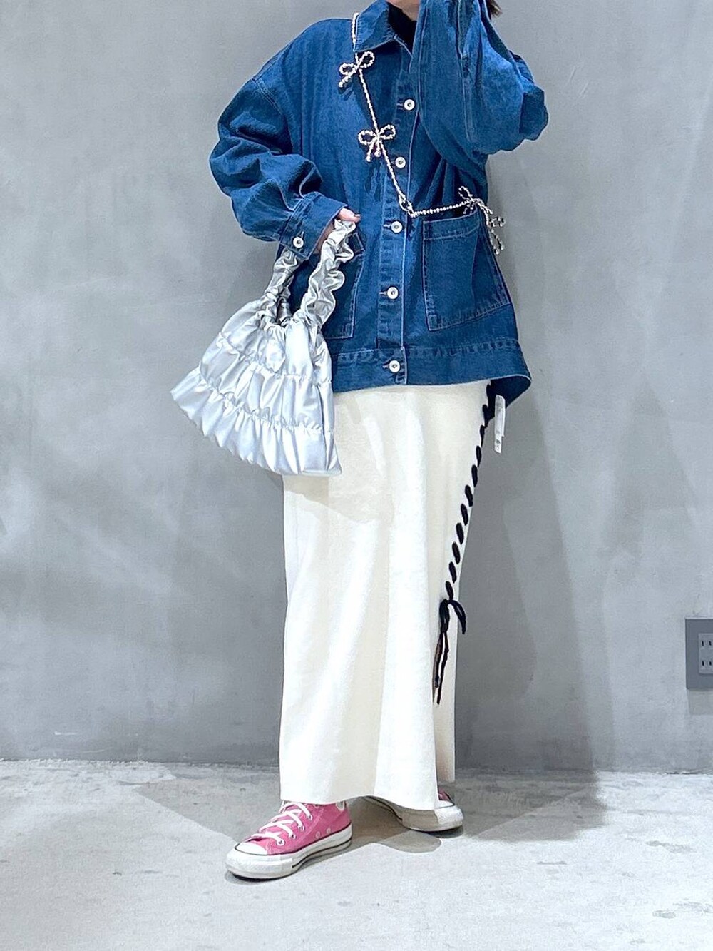 ベージュ系のスカート、シルバー系のショルダーバッグ、ブルー系のデニムジャケットを着用したレディースの冬コーディネートの5枚目の写真