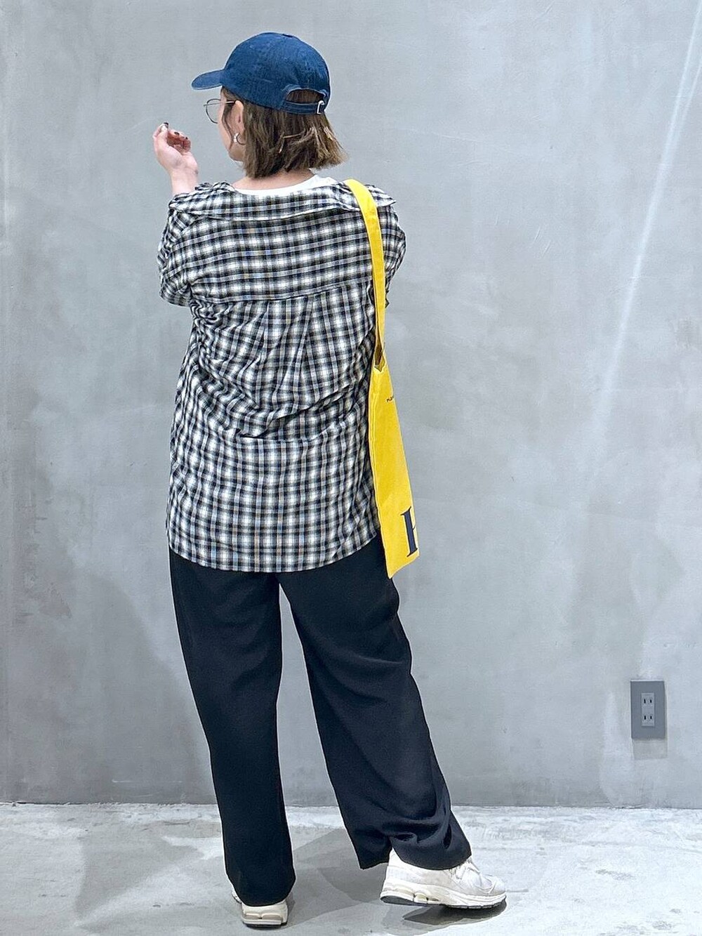 ブラック系のその他パンツ、ブラック系のシャツ/ブラウス、イエロー系のトートバッグを着用したレディースの春コーディネートの2枚目の写真