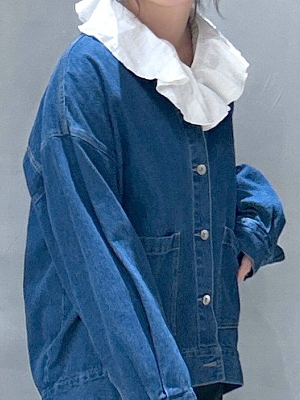 シルバー系のショルダーバッグ、ブルー系のデニムジャケット、ホワイト系のシャツ/ブラウスを着用したレディースの冬コーディネートの3枚目の写真