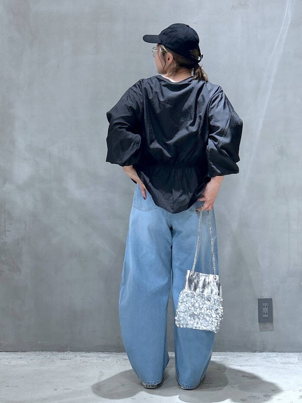 ブルー系のデニムパンツ、ブラック系のスウェット、その他のショルダーバッグを着用したレディースの冬コーディネートの2枚目の写真